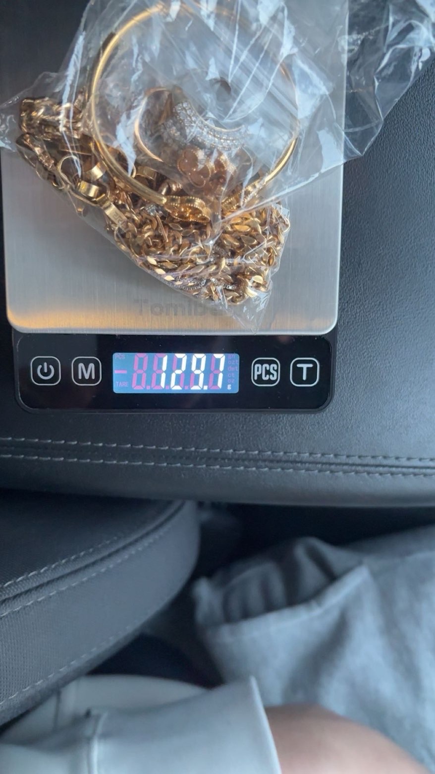 Gold jewellery in a clear bag on a scale inside a vehicle