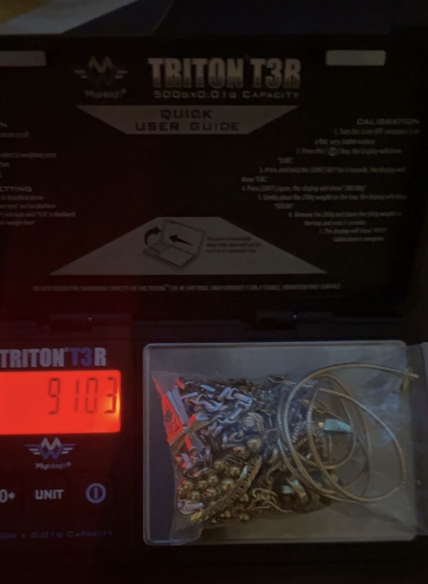 Gold jewellery in a bag on an open scale with a red display