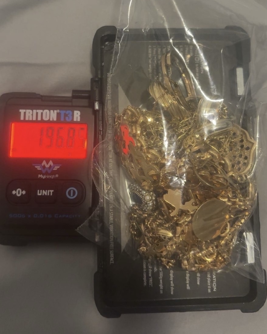 Assorted gold jewellery in a clear bag on a scale