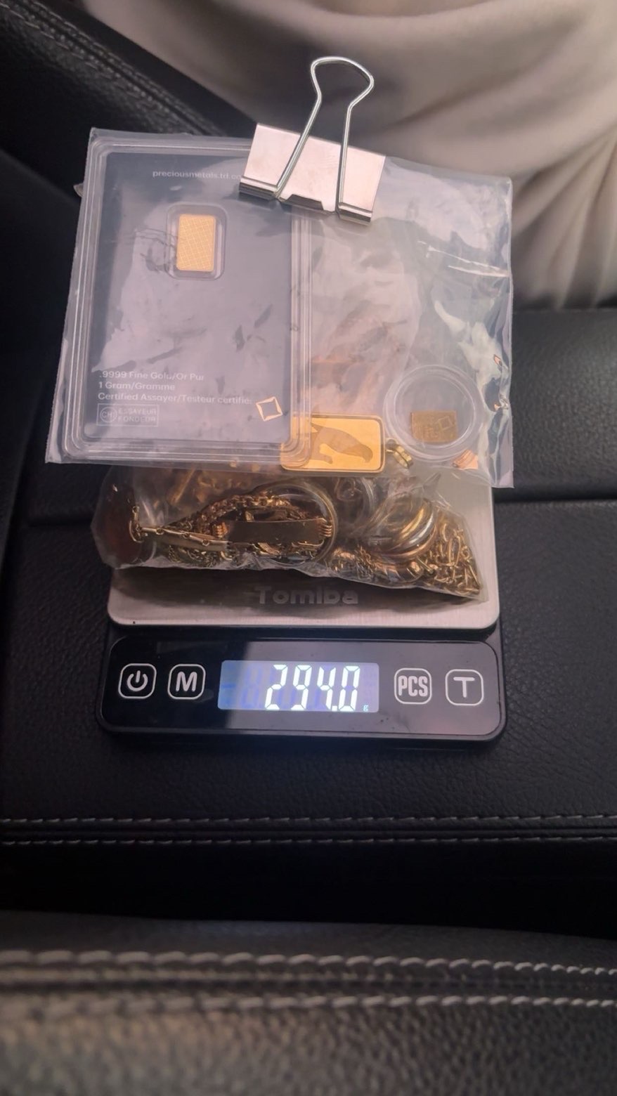 Gold jewellery in a clear bag with a clipped paper above a scale display
