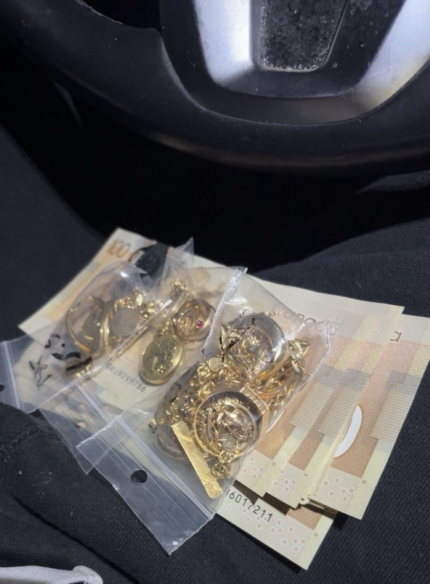 Bags of gold jewellery resting on Canadian banknotes