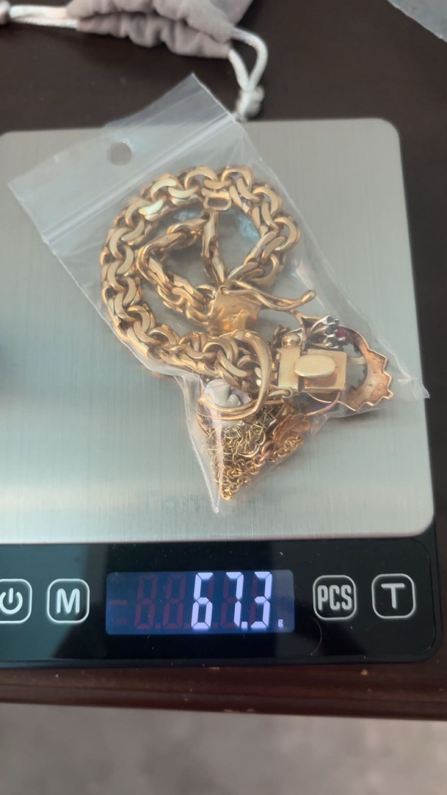 Gold chain and assorted jewellery in a clear bag on a scale