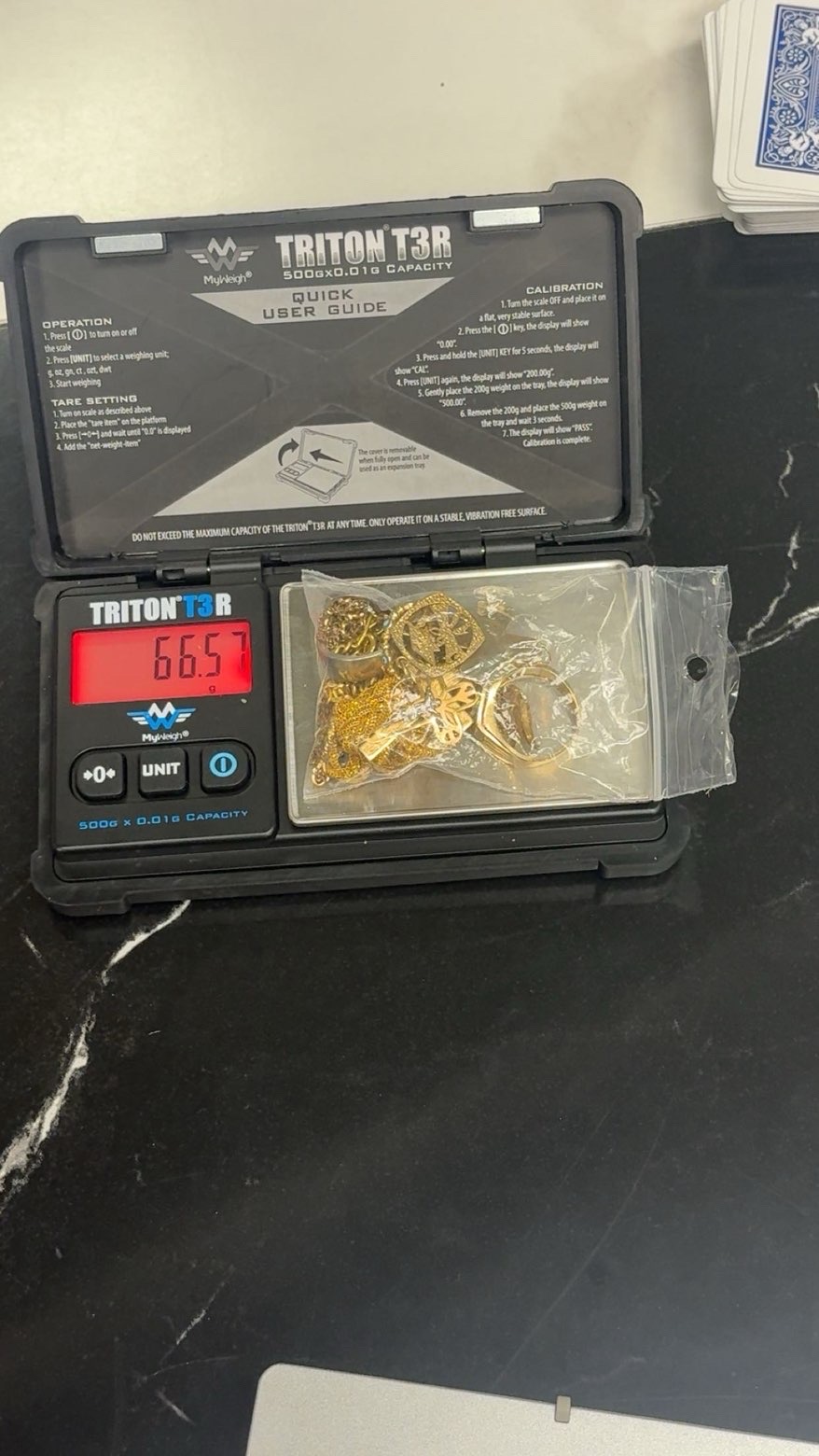 Bagged gold pendants and rings on an open digital scale
